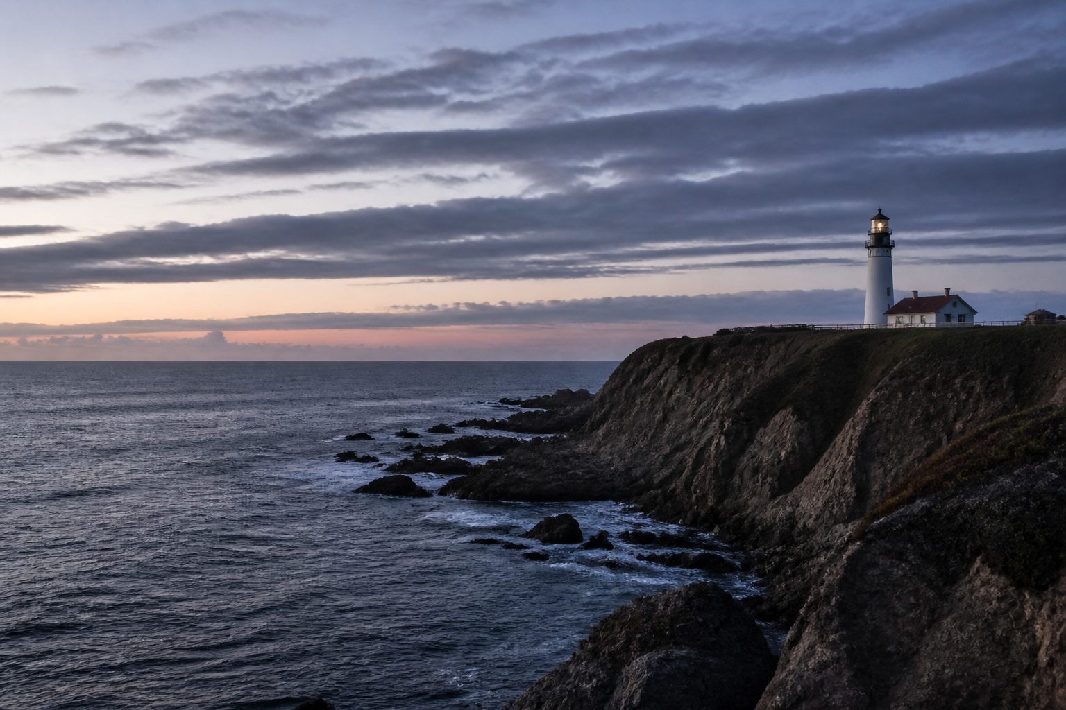 Coastal cliff and lighthouse at blue hour